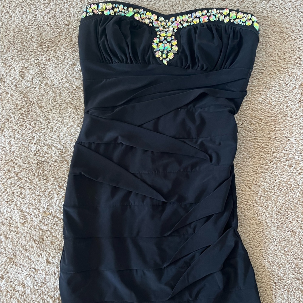 Strapless black dress with gems on the top. Comes slightly above the knee